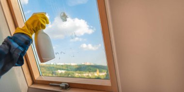 Kadın evin içini elle temizliyor. İçinde sprey temizleyici ve paspas olan bir bez parçası var. İlkbaharda düzeni ve temizliği sağlamak, bayan hizmetlerini temizlemek.