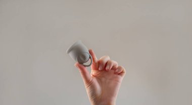 Alternatif kadın hijyen ürünleri olarak adet bardakları, hipoalerjenik silikon regl bardağı tutan kadın..