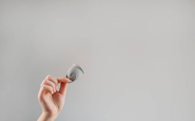 Bir kadının elinde regl bardağı tutarken, kadın sağlığı ve rahatlığı için eczanelerde bulunan hijyen ürünlerinin tanıtımı yapılıyor..