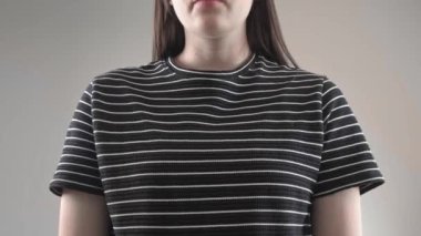 Bir kadın banyoda elinde tampon, diğer elinde regl bardağı tutarak kadın hijyen seçimini sembolize ediyor..