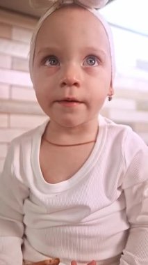 Masada elinde oklavayla oturan küçük kız, Noel sofrası için annene zencefilli kurabiye pişirmesinde yardım ediyor..