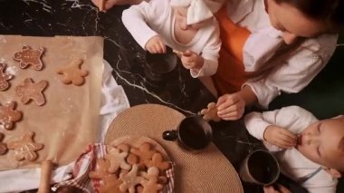 Anne ve kızı birlikte zencefilli kurabiye pişiriyorlar, tatillerde evde sıcak ve rahat bir ortam yaratıyorlar..