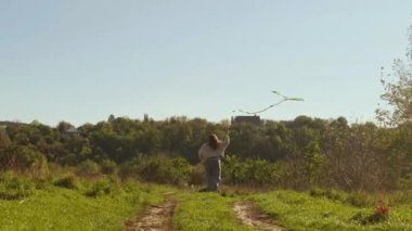 Annesinin yardımıyla açık havada uçurtma uçuran mutlu çocuk kaliteli zaman geçirmeyi ve dışarıda eğlenmeyi seviyor..