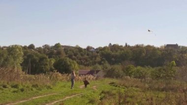 Bir çocuk parkta uçurtmayla neşeli bir şekilde koşar, bir anne ve oğlu açık havada aktif bir şekilde eğlenirken, hayat dolu bir yaşam tarzını benimser..