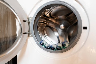 Çamaşır makinesinin variline yerleştirilmiş çamaşır kapsülleri, hem sağlık hem de çevre için güvenli çevre dostu deterjanlar sergiliyor..