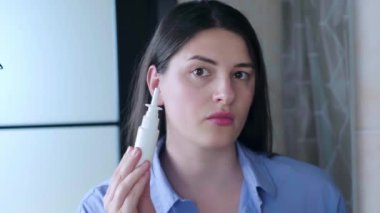 Kulak temizleme spreyi kullanan bir kadın banyoda kulaklarını temizliyor. Yüksek kalite 4k görüntü