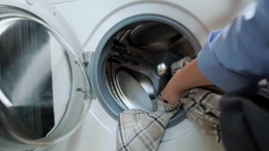 Bir kadın çamaşır makinesinden kuru temizleme giysilerini çıkarıp evde kurutma makinesi kullanmanın rahatlığını gösteriyor. Yüksek kalite 4k görüntü