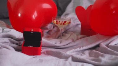 Güzel dekore edilmiş Sevgililer Günü kahvaltısı kalp şeklinde balonlar, şampanya bardağı, hediye ve düşen kalp şeklinde balonlar. Yüksek kalite 4k görüntü