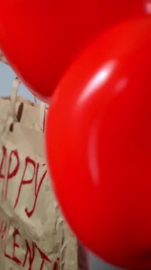 Kırmızı kalp şeklinde balonlarla dolu bir hediye çantasının yakın çekimi Sevgililer Günü 'nü kutlamak için mükemmel bir hediye. Yüksek kalite 4k görüntü