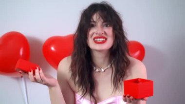 Kızın biri Sevgililer Günü hediyesi tutuyor ve kutlama için güzelce paketlenmiş bir hediye sunuyor. Yüksek kalite 4k görüntü