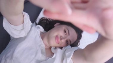 Kadın rahat bir ortopedik yatak ve yastıkta uyanıyor. Hafıza köpük yastıkları uyku kalitesini arttırmak için mükemmeldir. Yüksek kalite 4k görüntü