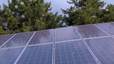 Yeşil bir park zeminine karşı güneş panelleri karbon emisyonu veya zararlı maddeler olmadan enerji üreterek çevresel etkiyi azaltıyor. Yüksek kalite 4k görüntü
