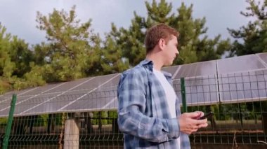 Enerji depolama mühendisi bir telefon tutuyor, verileri analiz ediyor ve raporlama ve performans takibi için telefona yüklüyor. Yüksek kalite 4k görüntü