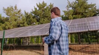 Mühendis sırt üstü duruyor, güneş panellerinin en uygun konumunu ve eğimini maksimum verim için hesaplıyor. Yüksek kalite 4k görüntü