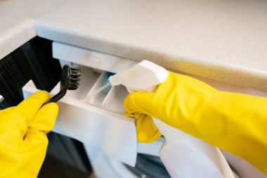 Hizmetçi mutfağı temizler, düzenli olarak cihazların ömrünü uzatmak ve arızaları önlemek için birikimleri kaldırır..