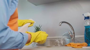 Kolay mutfak temizliğinin sırrı doğru ürünlerdir. Kadın saniyeler içinde çalışan bir temizleyiciyle lavaboyu temizliyor. Yüksek kalite 4k görüntü