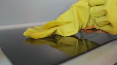 Kadın ev temizliği için eldiven takıyor, ellerini koruyucu eldivenlerle korurken mutfak temizliğine hazırlanıyor. Yüksek kalite 4k görüntü