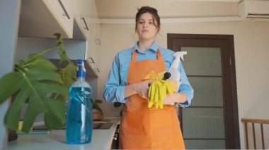 Kadın evde mutfağı temizlemeye hazırlanıyor. Temizlik doğru araçlarla başlar: fırça, giysi ve temizlik ürünleriyle dolu bir kutu. Yüksek kalite 4k görüntü