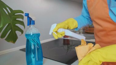 Mutfakta bahar temizliği, her detay önemlidir. Kadın temiz bir ev için sobayı etkin bir temizleyiciyle dikkatlice temizliyor. Yüksek kalite 4k görüntü