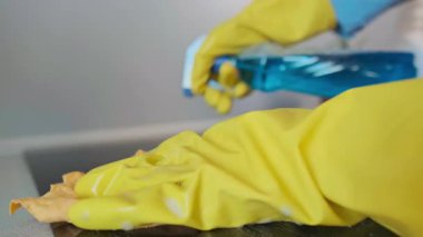 Kadın, siyah bir elektrikli ocağı bezle temizliyor, temiz bir parlaklık için temizleme solüsyonu sıkıyor. Yüksek kalite 4k görüntü