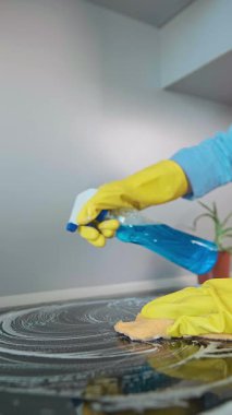 Bir kadın mutfak sobasını temizliyor. Düzenli temizlik yağ birikimini önler, gelecekteki temizliği kolaylaştırır ve zamandan tasarruf ettirir. Yüksek kalite 4k görüntü