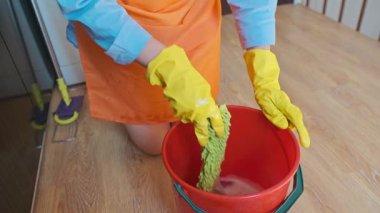 Bir kız kiri temizlemek için yerleri temizler. Islak paspas toprak parçacıklarını yakalar ve havaya karışmalarını engeller. Yüksek kalite 4k görüntü