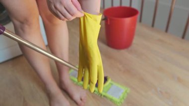 Temizlik görevlisi lastik eldiven giyer, temizlik ve güvenliğe özen göstererek kapsamlı bir temizlik işine hazırlanır. Yüksek kalite 4k görüntü