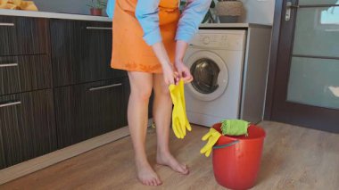 Temizlik uzmanı işe hazırlanır, temizlik işlemine başlamadan önce lastik eldiven giyer. Yüksek kalite 4k görüntü