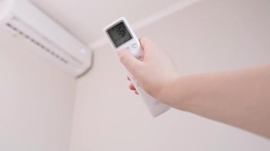 Akıllı ev eylemde: kadın uzaktan kumandayla aydınlatma ve aletleri kontrol ediyor, evinde mükemmel koşullar yaratıyor. Yüksek kalite 4k görüntü