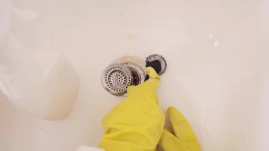 Profesyonel temizlik: kadınlar banyo giderlerini sünger ve güçlü temizlik kimyasallarıyla temizler. Yüksek kalite 4k görüntü