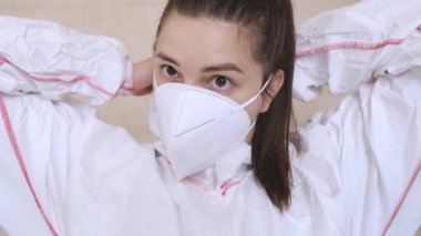 İş için hazırlık: koruyucu giysili sağlık görevlisi hastanede prosedürden önce kaput takıyor. Yüksek kalite 4k görüntü