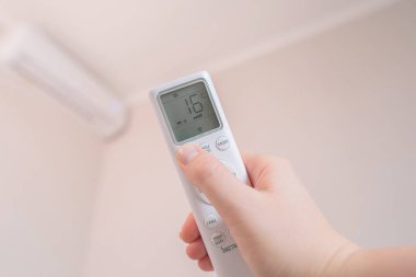 Akıllı evi uzaktan kumandayla kontrol eden kadın evinde rahat bir atmosfer yaratıyor..