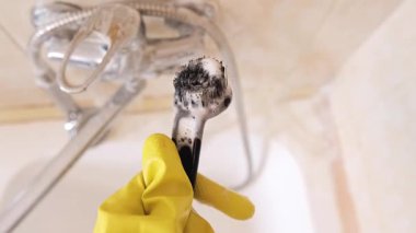 Eldeki fırçayla, temizlik uzmanı detaylara odaklanıyor: kadın derin temizlik için sünger ve temizlik kimyasalları kullanarak banyoyu temizliyor. Yüksek kalite 4k görüntü