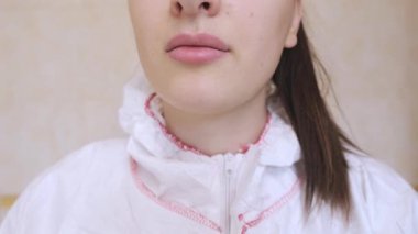 Koruyucu giysili kadın doktor, güvenliği sağlamak ve tedbirlere uymak için maske takarak işe hazırlanıyor. Yüksek kalite 4k görüntü