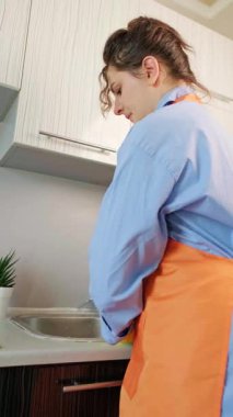 Mutlu kız mutfağı temizlemeyi bitirdi, profesyonel ev temizliği için temizlik ürünleri tutuyor. Yüksek kalite 4k görüntü