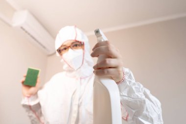 Koruyucu giysili kadın klimayı temizliyor, sağlık ve rahatlık için temiz ve temiz hava sağlıyor..