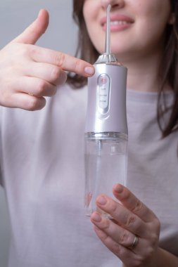 Su temizleyicisi kullanan bir kadın düzgün bir ağız bakımı gösterir. Gün boyunca taze nefes ve temiz dişlere yardımcı olur..