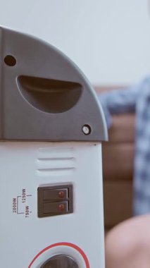 Enerji krizi sırasında, bir adam evinde rahat bir sıcaklık yaratmak için ısıtıcı ve yalıtım malzemesi kullanır. Yüksek kalite 4k görüntü