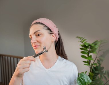 Metal silindirli lenfatik drenaj masajı: kadın cilt rengini arttırır ve evdeki soğutma etkisinden hoşlanır.