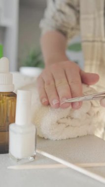 Bir kadın tırnak etlerini geriye atarak ve oje sürerek tırnak bakımını güçlendirir. Yüksek kalite 4k görüntü