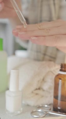 Evde bakım: bir kadın tırnak bakımı için tırnak içi serumu uygular, sağlıklı tırnaklar ve pürüzsüz eller sağlar. Yüksek kalite 4k görüntü