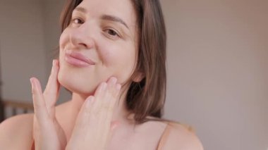 Kadın cildini nemlendirici ve vitaminle nemlendirmek için yüz maskesi kullanıyor. Yüksek kalite 4k görüntü