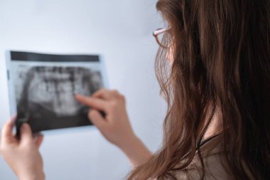 Kadın dişçi diş röntgeni çeker ve hasta için en iyi tedavi planını belirler..