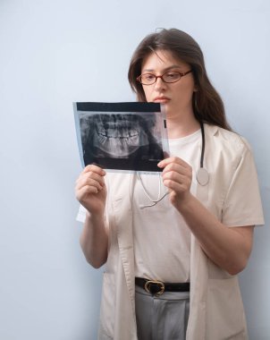 Sağlıklı dişler için doğru teşhis ilk adımdır: dişçi etkili tedavi için X-ray görüntüsünü analiz eder.