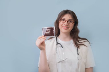 Kadın doğum uzmanı ve jinekolog ultrason görüntülerini inceleyerek hastalara hamilelik planlaması tavsiyeleri veriyor..