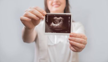 Kadın doğum uzmanı ultrason sonuçlarını hastaya açıklayarak gebelik ve vitamin tedavisi için ideal yöntemler sunuyor..