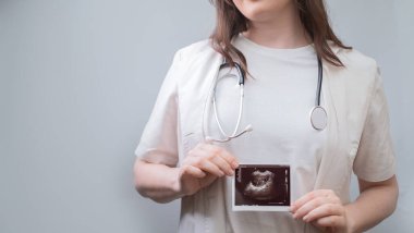 Kadın doğum uzmanı ultrason görüntüsünü analiz eder, hamilelik ve potansiyel vitamin terapisi hakkında tavsiyeler verir..