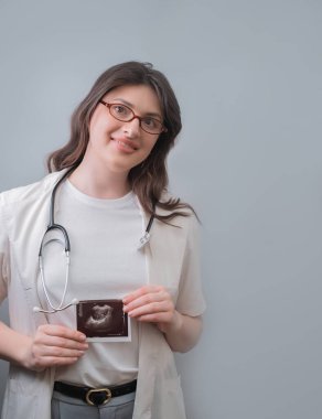 Doğum uzmanı-jinekolog hastaya ultrason kullanarak kişiselleştirilmiş bir tedavi planı hazırlıyor ve hamileliğe hazırlanıyor..