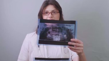 Kadın dişçi, tedavi sürecini izlemek ve diş bakımındaki komplikasyonları önlemek için röntgen kullanır. Yüksek kalite 4k görüntü