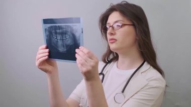 Diş hekimi, gizli diş sorunlarını tespit etmek ve doğru teşhis koymak için röntgenleri karşılaştırarak kapsamlı bir inceleme yapar. Yüksek kalite 4k görüntü